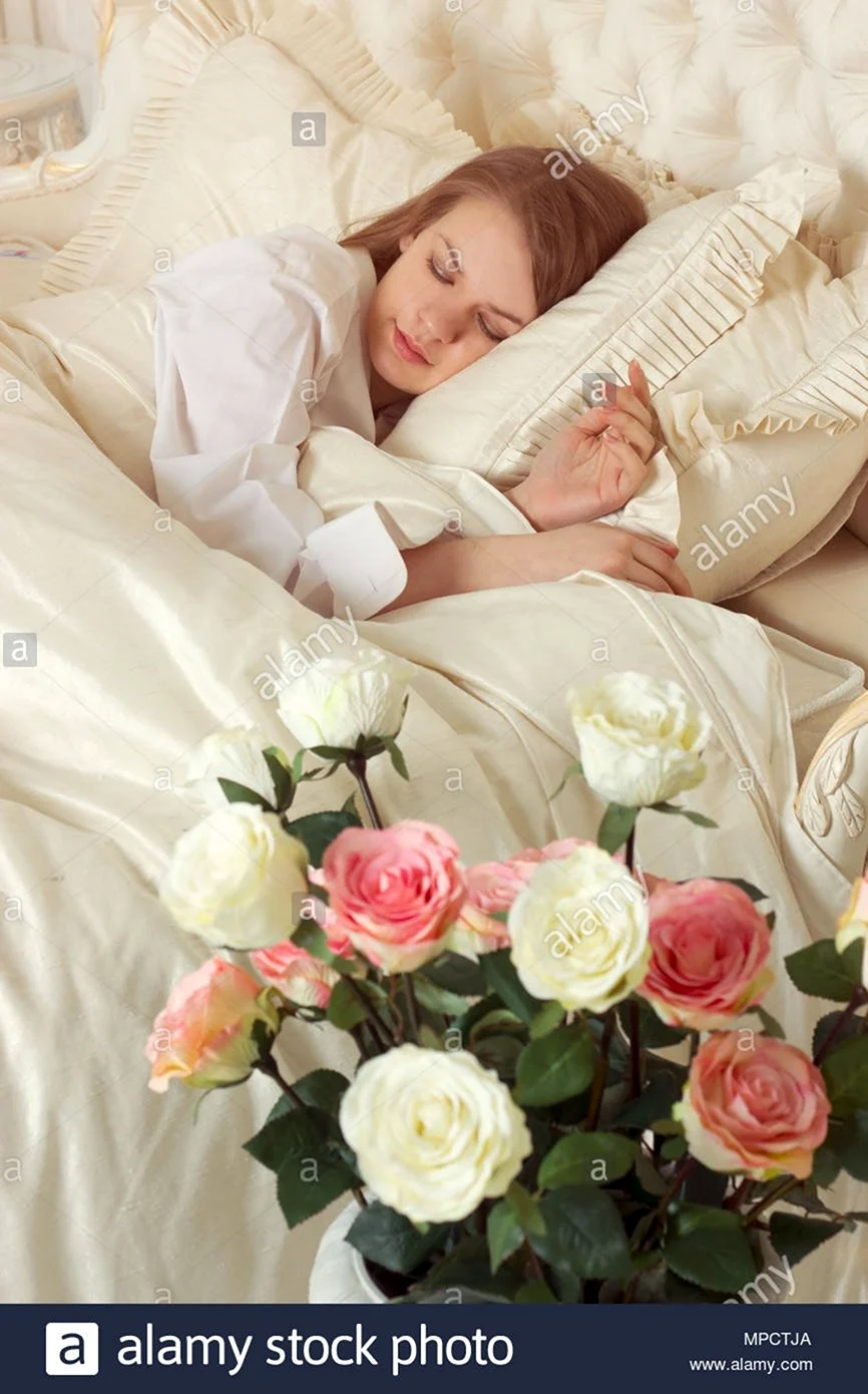 Белые розы в кровати девушки