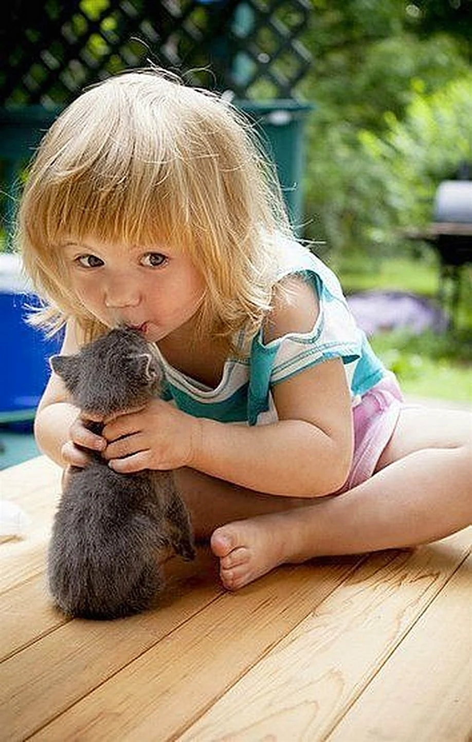 Девочка целует котенка
