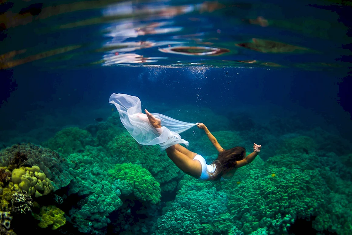 Девушка плавает в море под водой