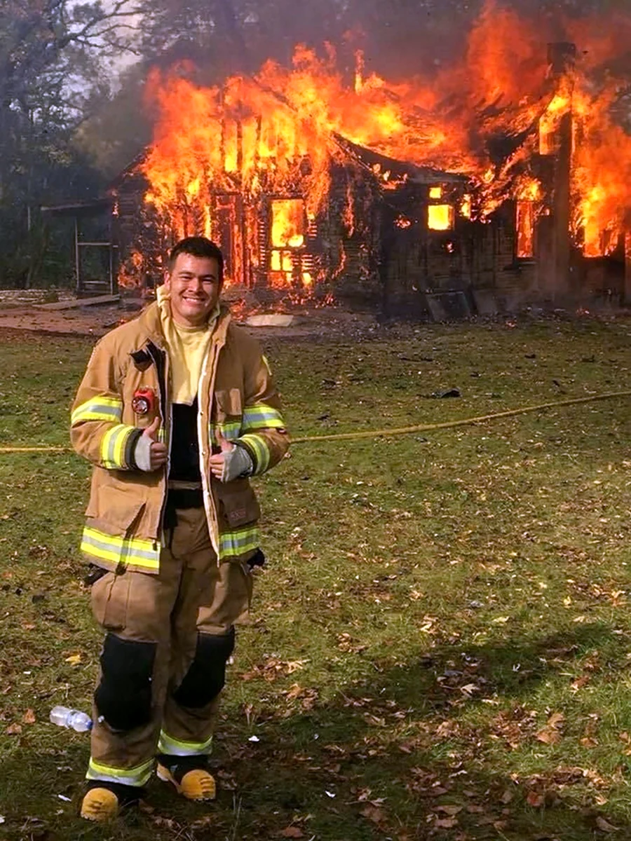 Пожарники на фоне горящего дома